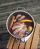 Octopus cooling in a pan of cooking liquid