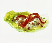 Cheese spread and red pepper on lettuce leaf