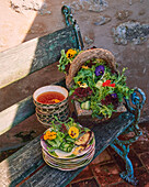 Mixed salad with edible flowers and soup out of doors