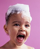 Little girl with her hair covered in shampoo, screaming