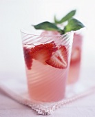 Two glasses of strawberry cocktail with lemonade and basil