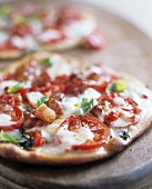 Pizza topped with pancetta, tomatoes and mozzarella