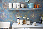 Wallpapered kitchen with shelf, cabinet and crockery
