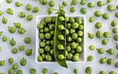 Peas in and beside a dish