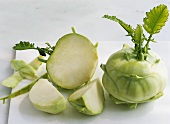 Whole kohlrabi and pieces on a chopping board