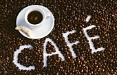 Cup of espresso and the word 'Café' in coffee beans