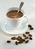 A cup of cocoa with cocoa beans