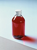 Glass bottle containing red medicine