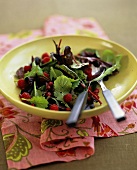 Salad leaves with pomegranate seeds and raspberries