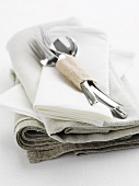 Cutlery on a pile of linen cloths