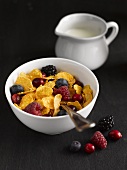Cornflakes with berries and a jug of milk
