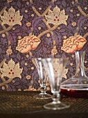 Wallpaper with a floral design and glasses with a carafe