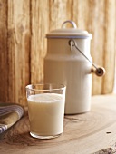Glass of milk in front of milk jug