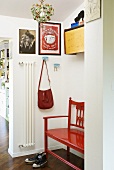 Shoes in front of a red bench in a vestibule