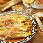 Baked chicory with pine nuts and Parma ham