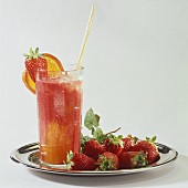 Orange and strawberry drink in glass