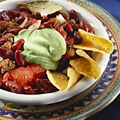 Chili con carne with avocado cream and nachos