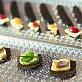 Pumpernickel appetisers with various potato spreads