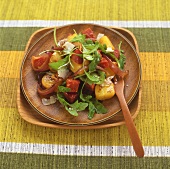 Kartoffel-Chorizo-Salat mit Rucola auf Holzteller