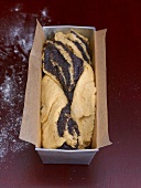 Unbaked poppy seed roulade in a loaf tin