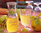 Quince syrup in carafe and in glass, diluted with water