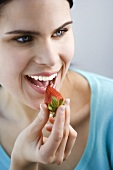 Junge Frau isst eine Erdbeere