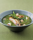 Green cream of asparagus soup with prawns and diced apple