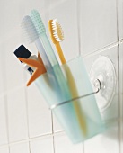 Toothbrushes and toothpaste in beaker