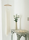 Candles and a vase of flowers on a small wooden table