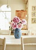 Peonies in a vase on a kitchen table