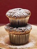 Two chocolate muffins, one on top of the other