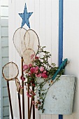 Landing net and flowers hanging on a wall