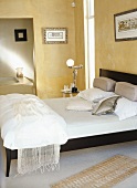 Gelbes Schlafzimmer mit Doppelbett, kunstvoller Nachttischlampe und Bad ensuite