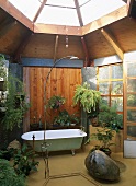 Freistehende Badewanne und offene Dusche unter verglaste Dachkuppel