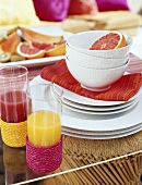 Glasses of juice and half grapefruit in bowl