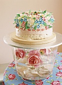 Glass bowl of roses with cake on top