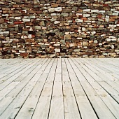 Wooden floor in front of stone wall