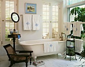 Bright bathroom with free-standing bathtub and antique furniture