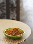 A spice mixture in a small dish on a rustic table
