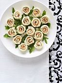Several salmon pinwheel sandwiches on a plate