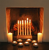 Brennende Kerzen vor Kamin