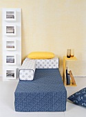 Moderne Schlafzimmerausstattung mit Regal, Beistelltisch und Bett in Gelb, Blau und Weiß