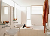 Schlichtes Badezimmer mit vielen Fenstern und großzügiger Badewanne