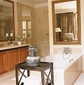 Einladendes Natursteinbadezimmer mit großem Barockspiegel über der Badewanne