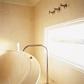 Detail einer Badezimmerecke aus Naturstein mit einem Langfenster