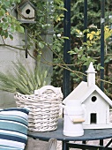 Gartentisch mit Vogelhäuschen und Weidenkorb