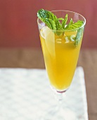 An apricot champagne cocktail with mint