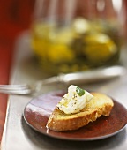 Goat's cheese in olive oil on baguette slice