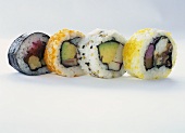 Vier verschiedene Maki-Sushi vor weißem Hintergrund