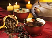 Pu-erh tea in tea bowl, loose tea leaves and pressed tea